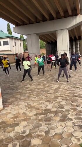 Morning workout crew trains under a Jos overpass