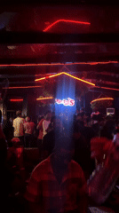 Late-night crowd dances at Abuja nightclub with neon lighting