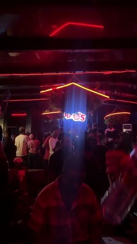 Late-night crowd dances at Abuja nightclub with neon lighting