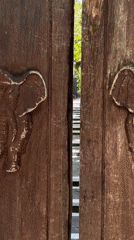 Carved elephant doors opened revealing jungle stairway in Kintamani