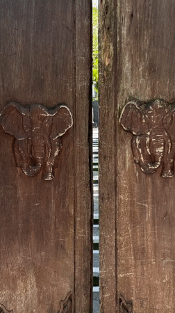 Carved elephant doors opened revealing jungle stairway in Kintamani