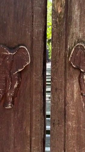 Carved elephant doors opened revealing jungle stairway in Kintamani