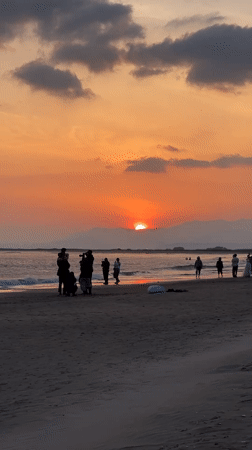 Sunset draws beachgoers to Busan shoreline amid dramatic skies