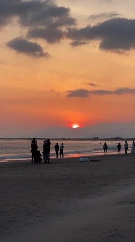 Sunset draws beachgoers to Busan shoreline amid dramatic skies