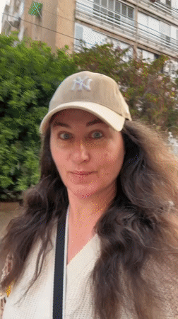 Woman rides electric scooter through Netanya streets in Yankees cap