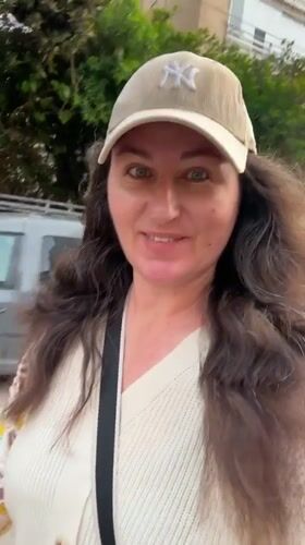 Woman rides electric scooter through Netanya streets in Yankees cap