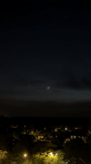 Crescent moon and light phenomena observed over residential area