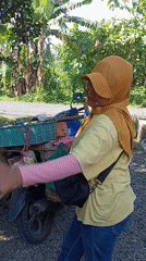 Woman with loaded motorcycle observed in Baron, Indonesia