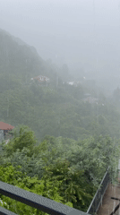 Rainy balcony view over Batumi's green hillside