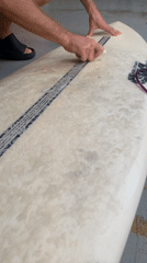 Surfer prepares equipment at Midigama surf shop
