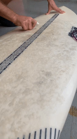Surfer prepares equipment at Midigama surf shop