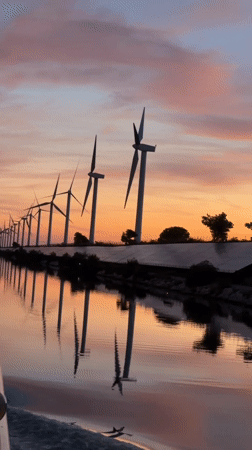 Solar panels and wind turbines at golden hour near Arles