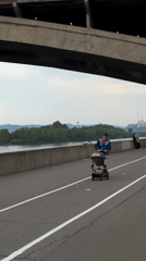 Daily life unfolds around Krasnoyarsk bridge: music, boats, families