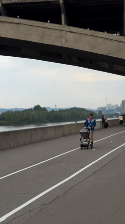 Daily life unfolds around Krasnoyarsk bridge: music, boats, families