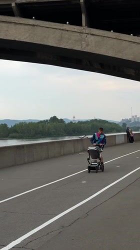Daily life unfolds around Krasnoyarsk bridge: music, boats, families