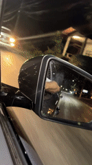 Nighttime traffic observed from vehicle mirror in Thailand