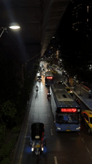 Evening traffic flows through wet Bangkok streets near Petchaburi intersection