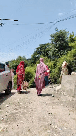 People gather on rural road in Haini, India
