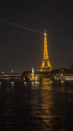 Eiffel Tower glowing at night over the Seine