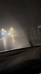 Motorist navigates heavy fog on wet roads in Kintamani