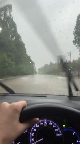 Driver navigates wet roads during heavy rainfall in Thailand