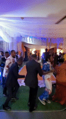 Wedding reception celebration captured with dancing guests, traditional attire