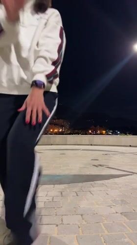 Woman dances on cobblestones in Tivat evening