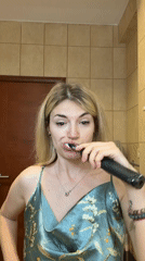 Woman brushes teeth in bathroom, Budva Montenegro morning