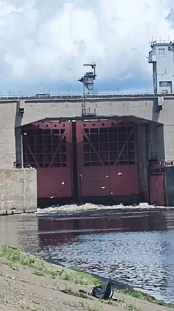 Cruise ships transit Chaikovsky dam locks while locals fish