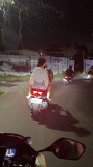 Motorcyclists ride through Mengwi streets at night