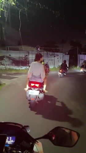Motorcyclists ride through Mengwi streets at night