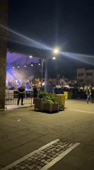 Outdoor night concert features band with colorful stage lighting