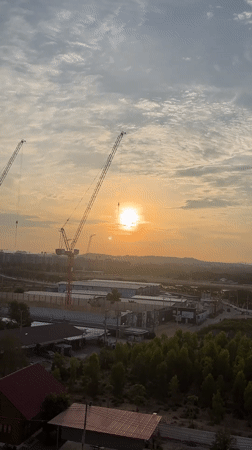 Construction cranes silhouetted against sunset in Pattaya City