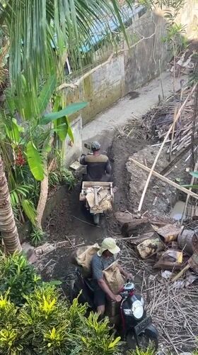 Two motorcyclists navigate narrow pathway in Ubud District
