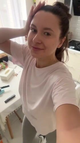 Woman exercises in kitchen during morning workout routine