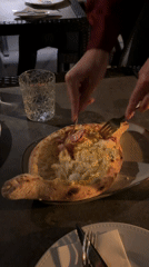 Diner enjoys Georgian khachapuri dish in Lisbon restaurant