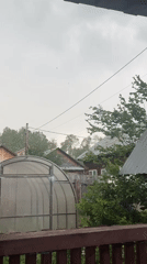 Woman documents rainy morning at rural Russian home