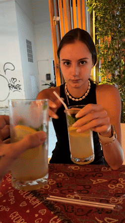 Two people toast drinks at outdoor restaurant in Rawai