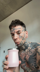 Tattooed man with pink cup observed indoors Buenos Aires