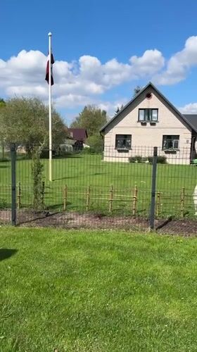 Woman with Shiba Inu enjoys sunny day in Carnikava backyard