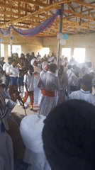 Religious ceremony with white-robed participants observed in building