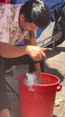 Man cleans bamboo pipe with water in Nha Trang