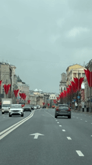 Red banners line Moscow street during cloudy morning