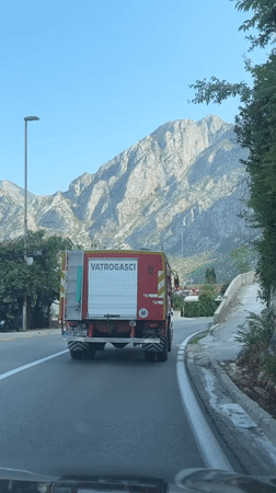 Fire truck rolls through Dobrota, Montenegro on a July morning