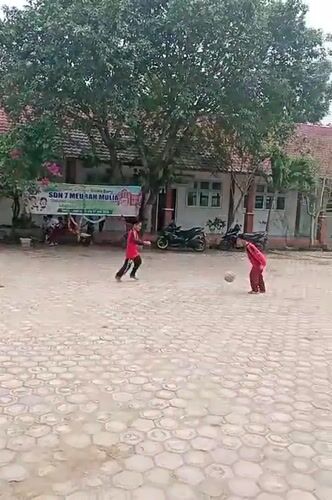 Kids play soccer in a flowering school courtyard in Indonesia