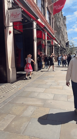 Costumed performers entertain crowds outside London's Hamleys toy store