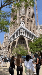 Tourists gather at Barcelona's Sagrada Familia on sunny afternoon