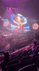 Large auditorium hosts elaborate concert performance with singer and dancers