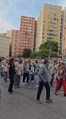 Elderly residents enjoy line dancing with live band in Spanish square