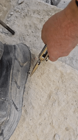 Person removes screw from stone surface in Ramat HaSharon